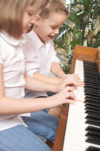 Brother and Sister Playing the Piano Together
