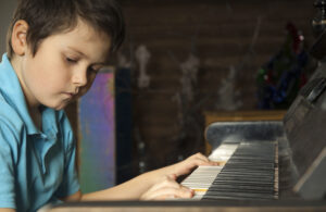 Studio shot of boy playing the piano. Serious face of little composer